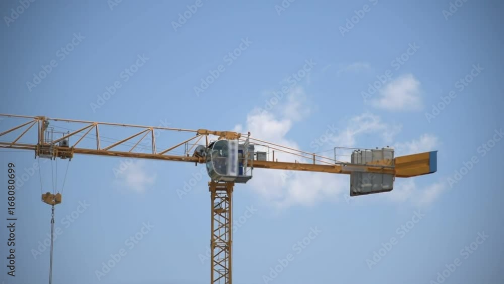 Big yellow crane rotating an moving its hook Big yellow crane rotating an moving its hook