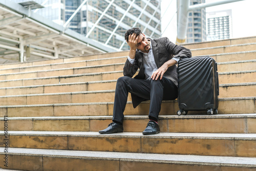 Unemployed businessman stress sitting on stair, concept of business failure and unemployment problem, work life balance.