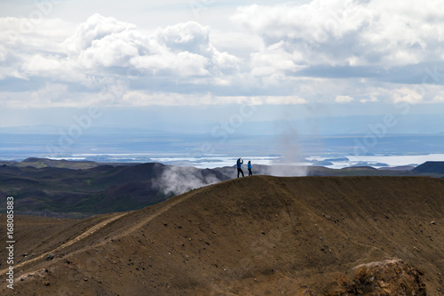 Young couple atop watching landscape. Concept of travel  investigation  exploring planet. Selective focus.