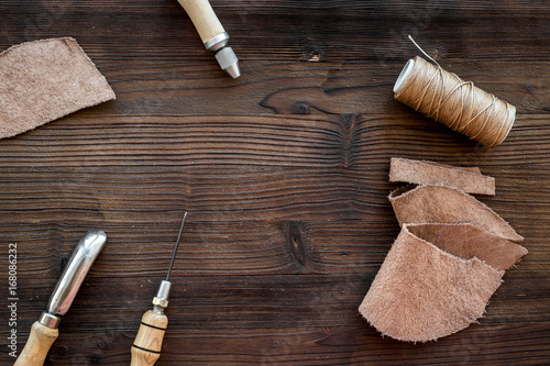 Tanner's workplace. Tools and matherials on dark wooden background top view copyspace photo