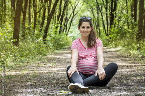 beautiful happy pregnant woman sitting on  in the  park © boryanam