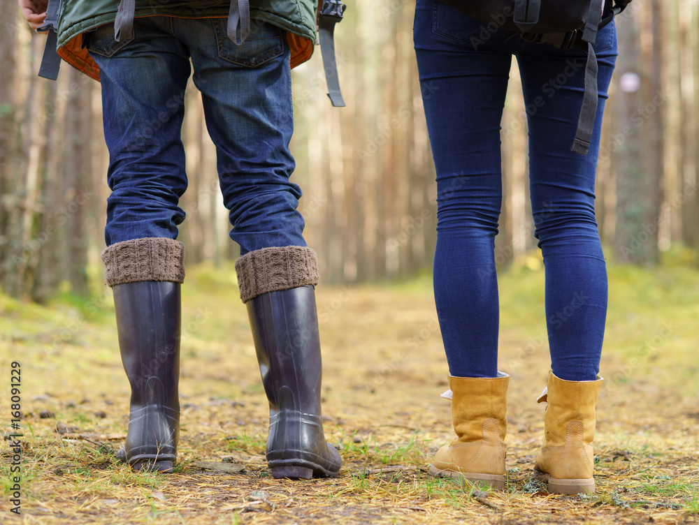 Close-up image of legs of a couple walking in forest. Camp, tourism, hiking concept. Close-up image of legs of a couple walking in forest. Camp, tourism, hiking concept.