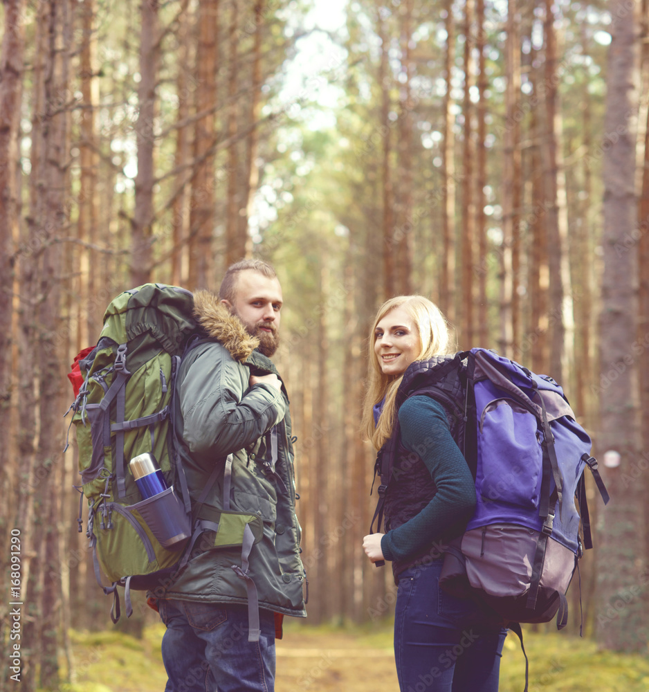 Young beautiful couple walking in forest. Camp, tourism, hiking concept.