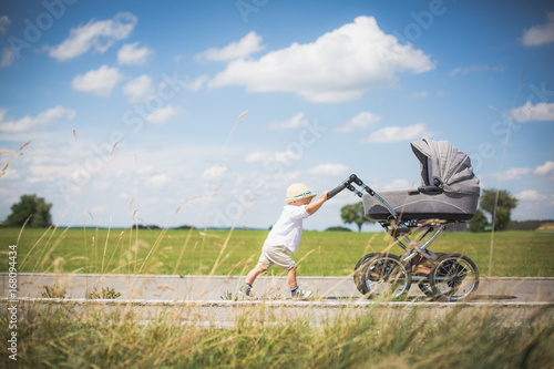 Foto Little brothers on a summer day with a stroller
