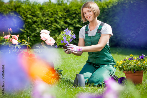 Wallpaper Mural Young smiling woman florist working in the garden Torontodigital.ca