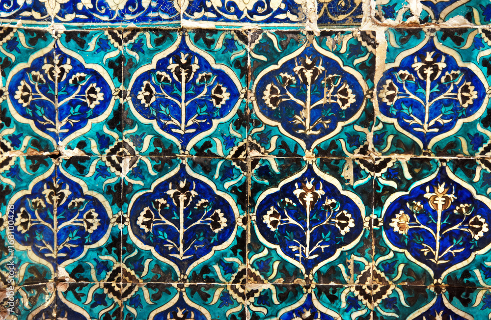 Fragment of the facade decoration of the mosque. Ancient tiles painted by hand. Kashan. Iran.
