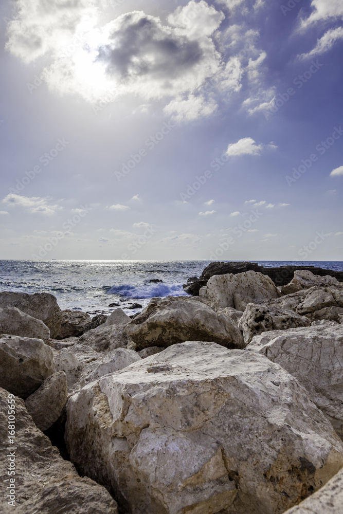 Vertical seascape with big rocks at Caesarea national park coast high sun and blue sky