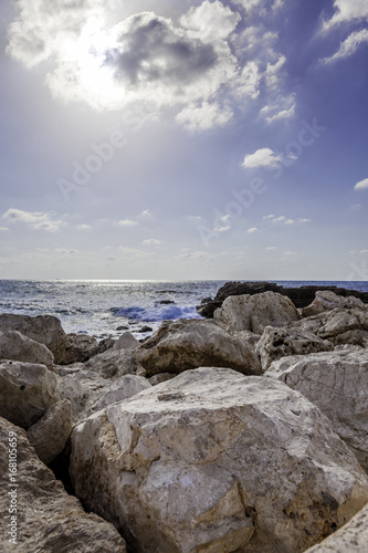 Vertical seascape with big rocks at Caesarea national park coast high sun and blue sky