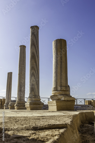 Doric white marble columns ruins from low angle with sewer drain in floor Caesarea national park 