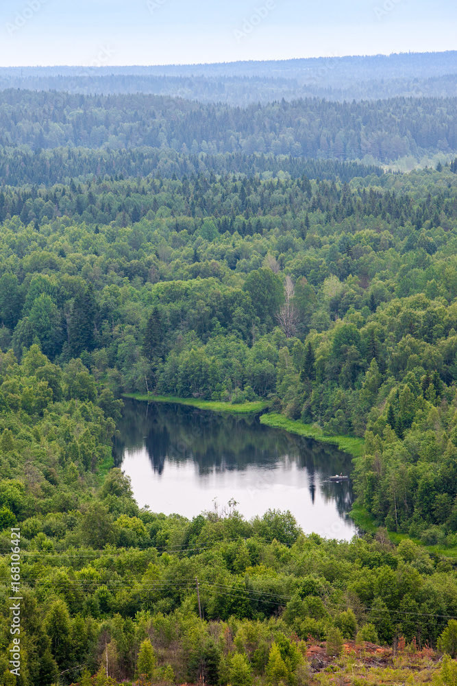 aerial view over the small lake and island surrounded by forests