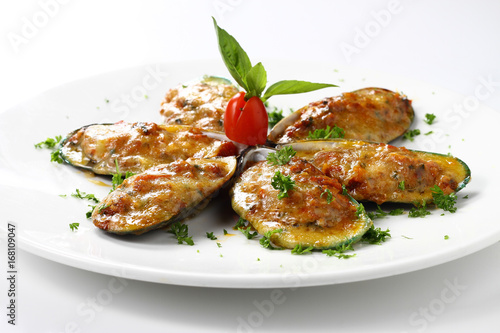 Baked New Zealand Mussels Six Pieces with Cheese on White Circle Dish, Isolated on White Background with Shadow. Close-up Low Angle Side View, Selective Focus at Food.