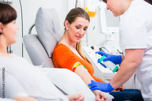 Nurse in hospital disinfecting puncture point before blood donation