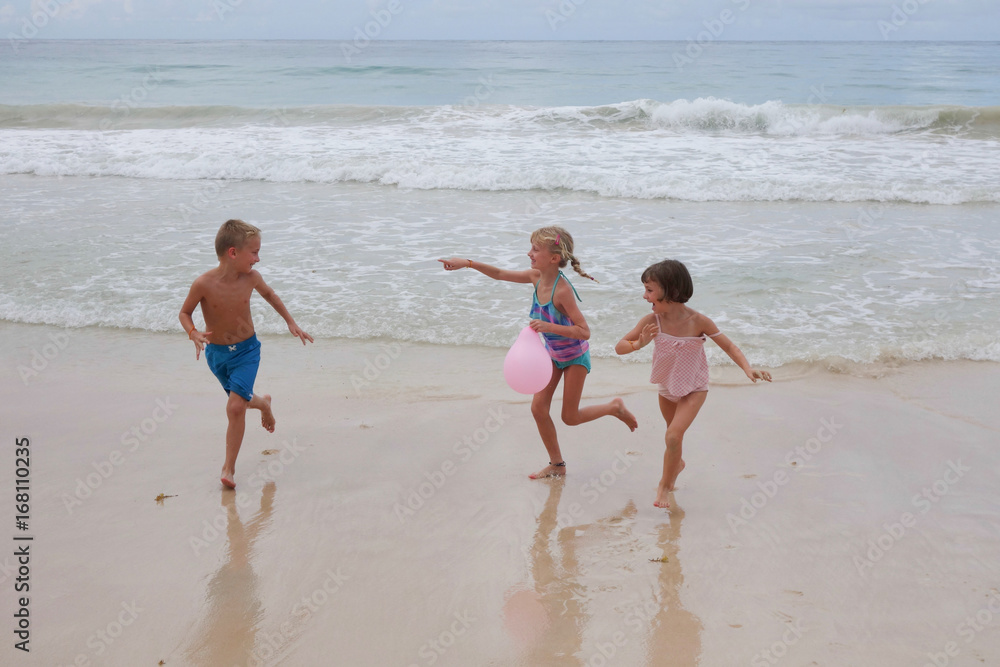 Three young children playing on the beach Three young children playing on the beach