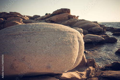 Huge stone and the sea behind / Beautiful rocky shore in Greece while sun rising