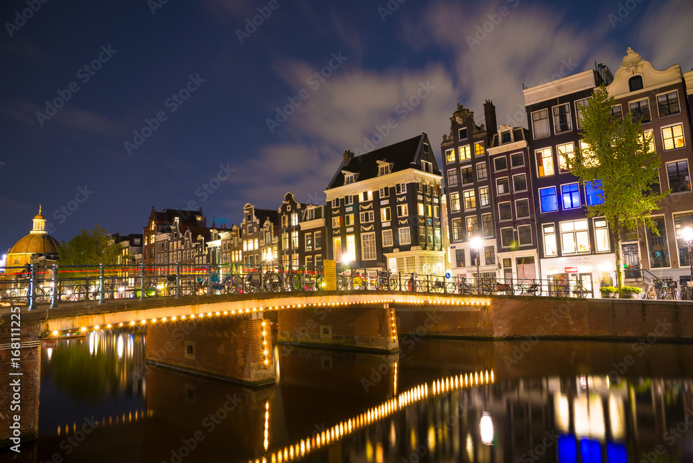 Famous Amstel river and night view of beautiful Amsterdam city. Netherlands
