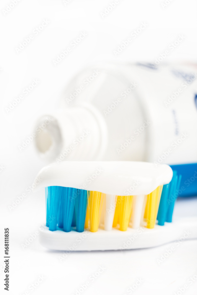 Toothpaste on toothbrush in closeup macro with toothpaste in the background
