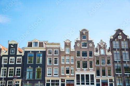 Typical old houses of Amsterdam, Netherlands under blue sky.