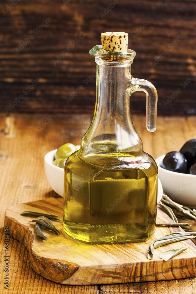 Organic olive oil bottle on rustic wooden background Organic olive oil bottle on rustic wooden background