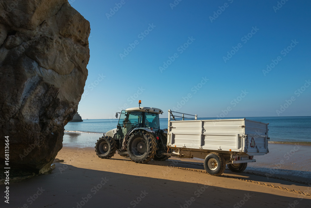 Tractor with trailer carry out beach maintenance