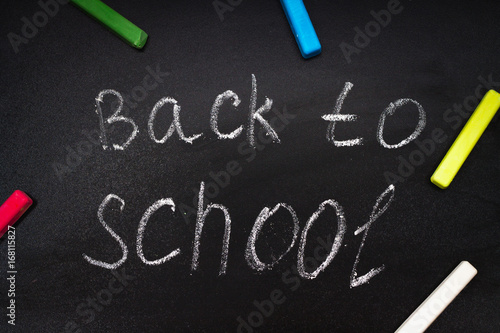 Back to school message on Blackboard inscribed with colorful chalk for background.