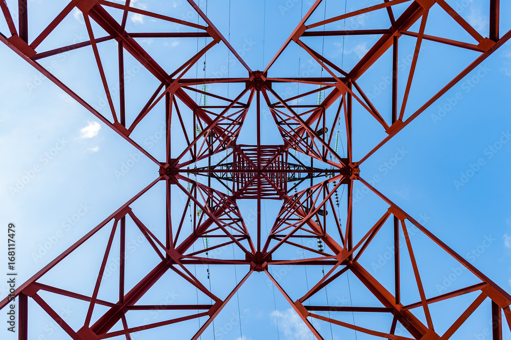 Bottom view of power pylons with blue sky on background. Bottom view of power pylons with blue sky on background.