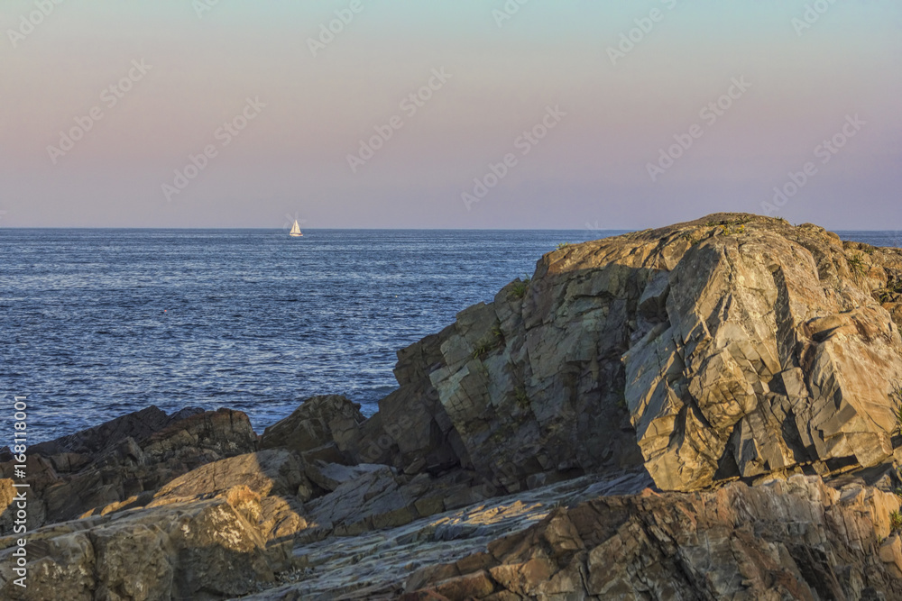 Tiny Sailboat on Horizon at Sunset Off Coast of Maine