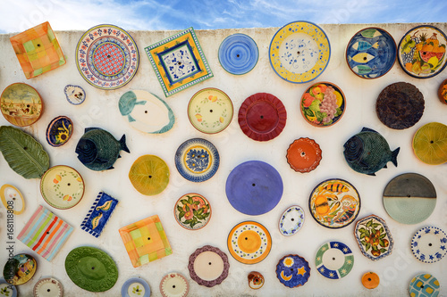 Colourful local pottery at a house wall in the Algarve, Portugal