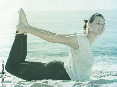 Obraz na plátně Woman in white T-shirt is practicing asana