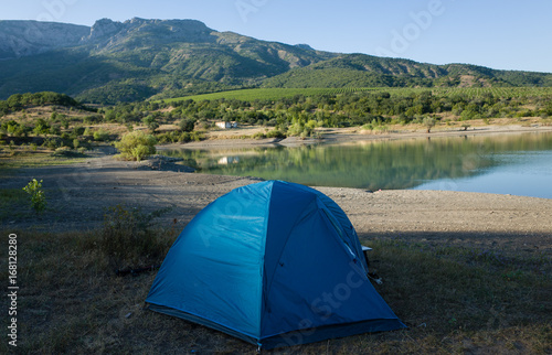 Blue tent on the shore of a mountain lake