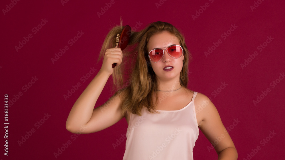 Young cute girl with comb, studio Young cute girl with comb, studio