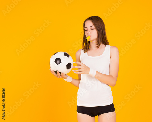 Young cute girl holds a soccer ball, studio  