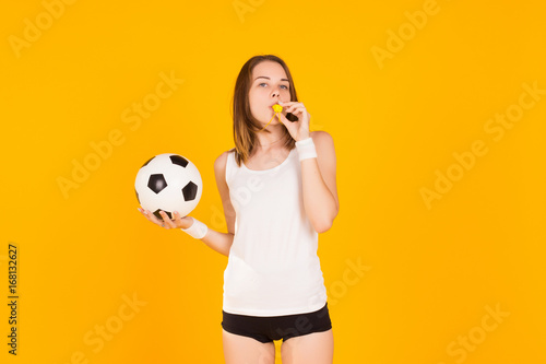 Young cute girl holds a soccer ball, studio  