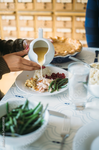 Pouring gravy on Thanksgiving dinner