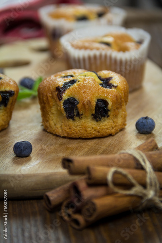 Muffins with blueberries, chocolate and cinnamon on a wooden board. Close-up. Sweet dessert