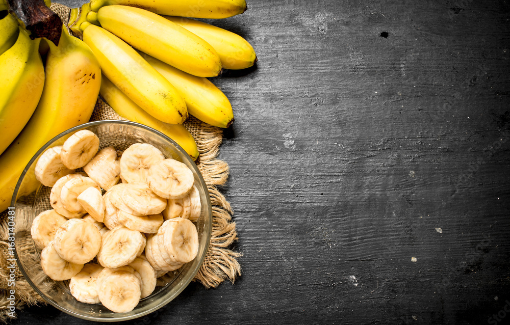 Ripe bananas with pieces of sliced bananas in a bowl . Ripe bananas with pieces of sliced bananas in a bowl .