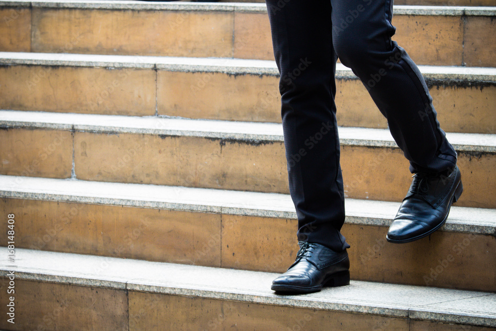 Close up of man's leather shoes while walking down the stairs in the city Close up of man's leather shoes while walking down the stairs in the city