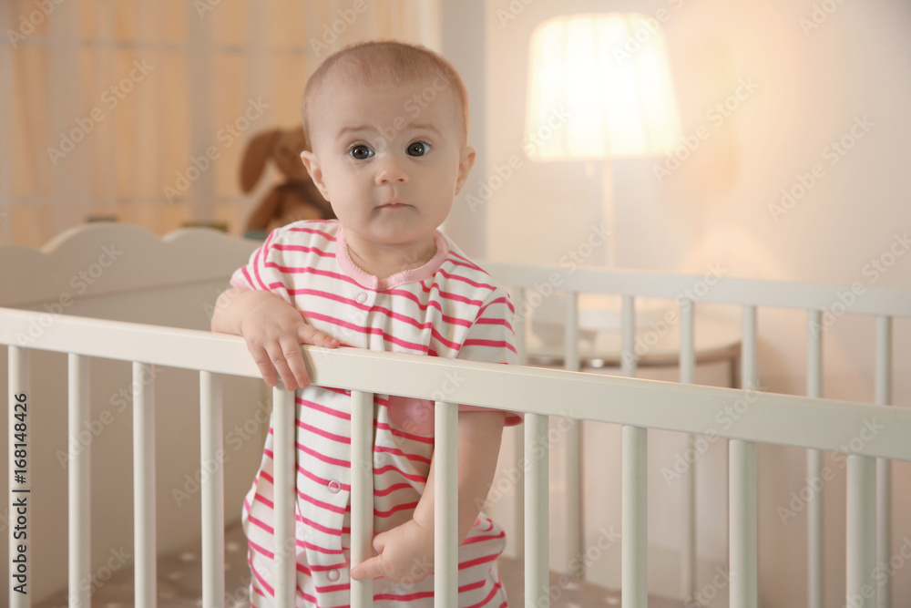 Cute little baby standing in crib at home Cute little baby standing in crib at home