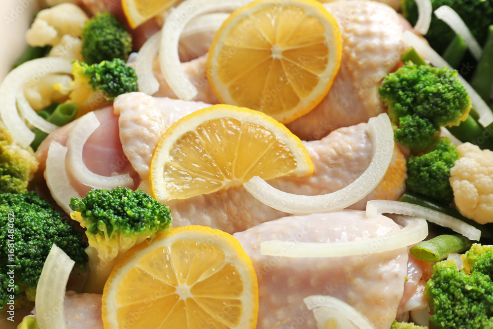 Raw chicken drumsticks with lemon and broccoli, closeup Raw chicken drumsticks with lemon and broccoli, closeup