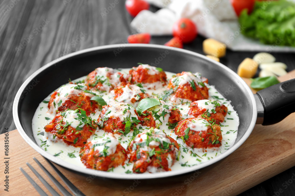 Frying pan with delicious turkey meatballs and sauce on table Frying pan with delicious turkey meatballs and sauce on table