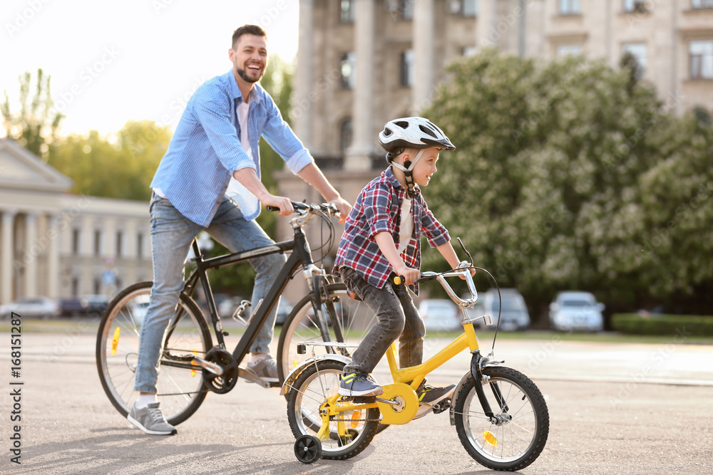 Dad and son riding bicycles outdoors Dad and son riding bicycles outdoors