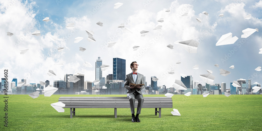 Young businessman or student studying the science and paper planes flying around Young businessman or student studying the science and paper planes flying around
