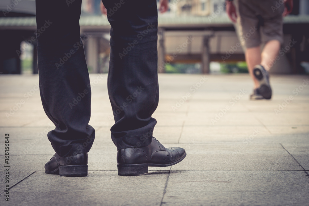 Close up of man's black leather shoes while he is standing and waiting in the city. Close up of man's black leather shoes while he is standing and waiting in the city.