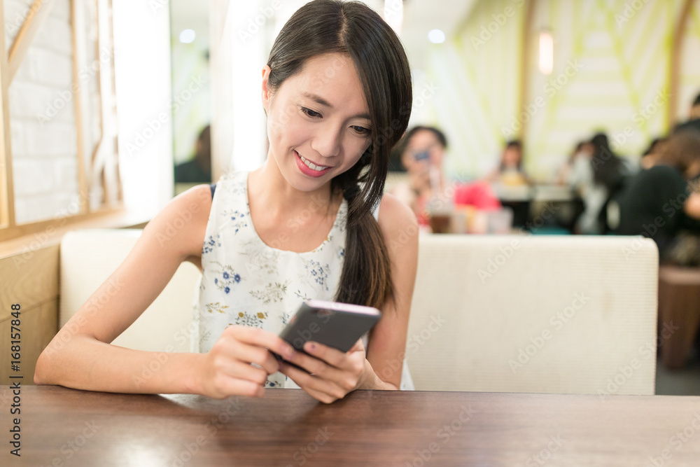 Woman using cellphone at restaurant Woman using cellphone at restaurant