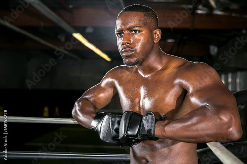 African american athlete during a cardio exercise routine with MMA gloves in boxing ring
