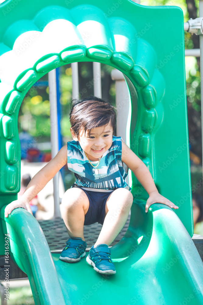 Cute boy is having fun with slider playing. Cute boy is having fun with slider playing.