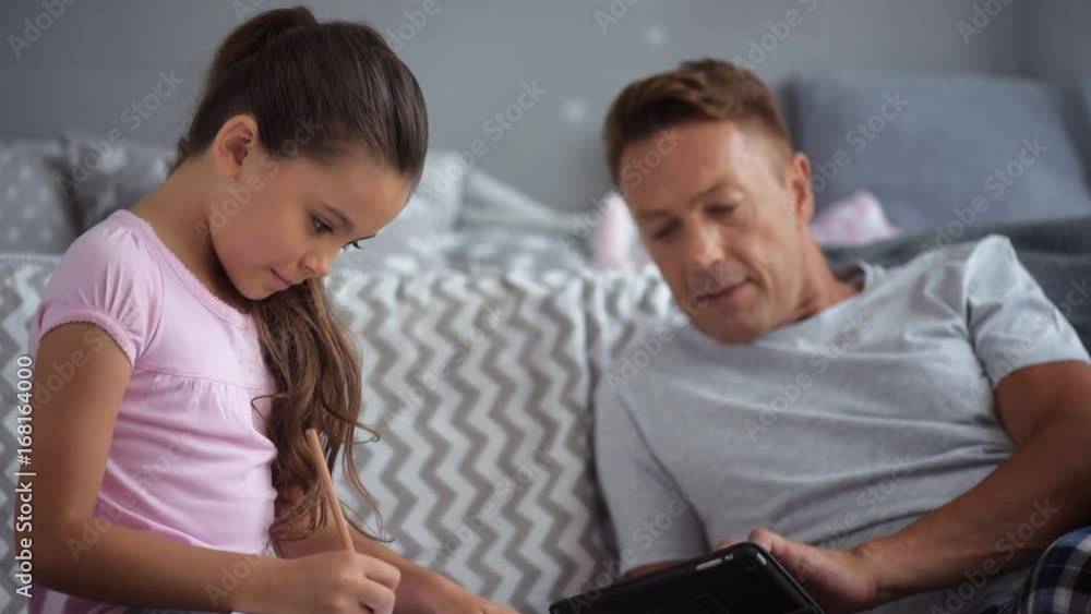 Pleasant little girl making her home assignment Pleasant little girl making her home assignment
