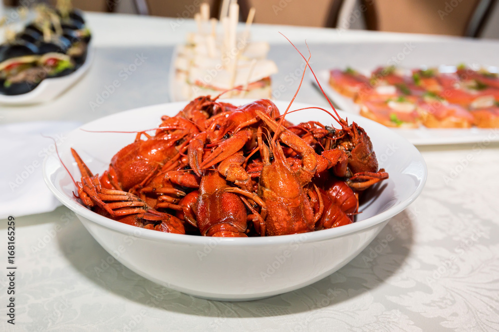 Cooked crayfishes in white plate on table Cooked crayfishes in white plate on table