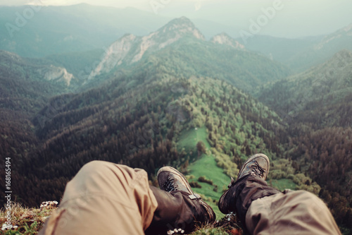 Male explorer sitting in mountains, pov image. © Alex Photo