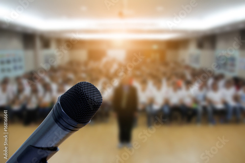 Microphone over the Abstract blurred photo of conference hall or seminar room with attendee background,Small Business training concept