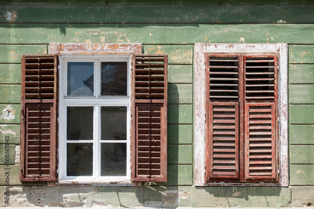 Detail of facade with old windows in rustic ancient house in Sibiu city, Romania Detail of facade with old windows in rustic ancient house in Sibiu city, Romania